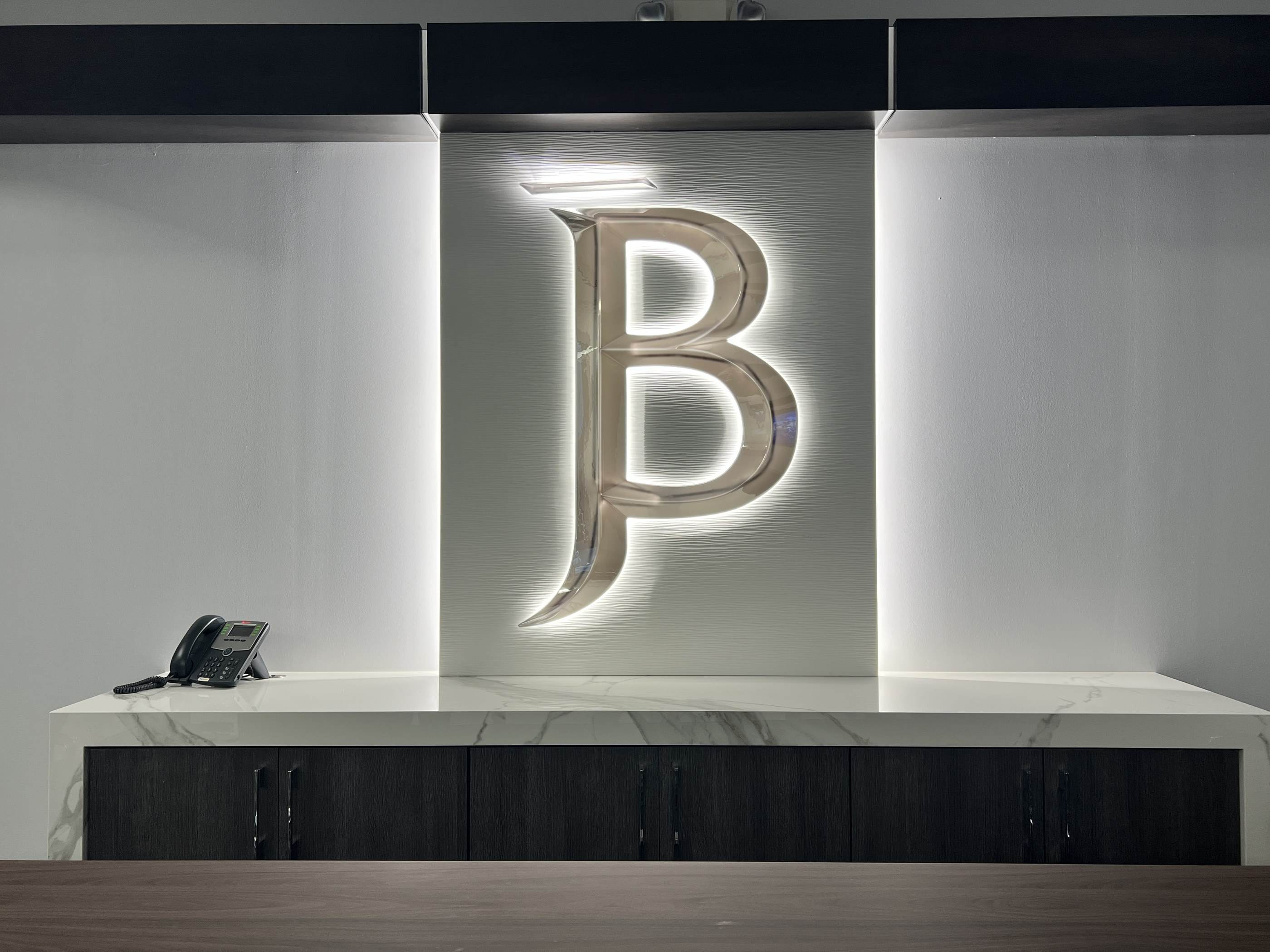 The backlit JB monogram in the firm’s conference room